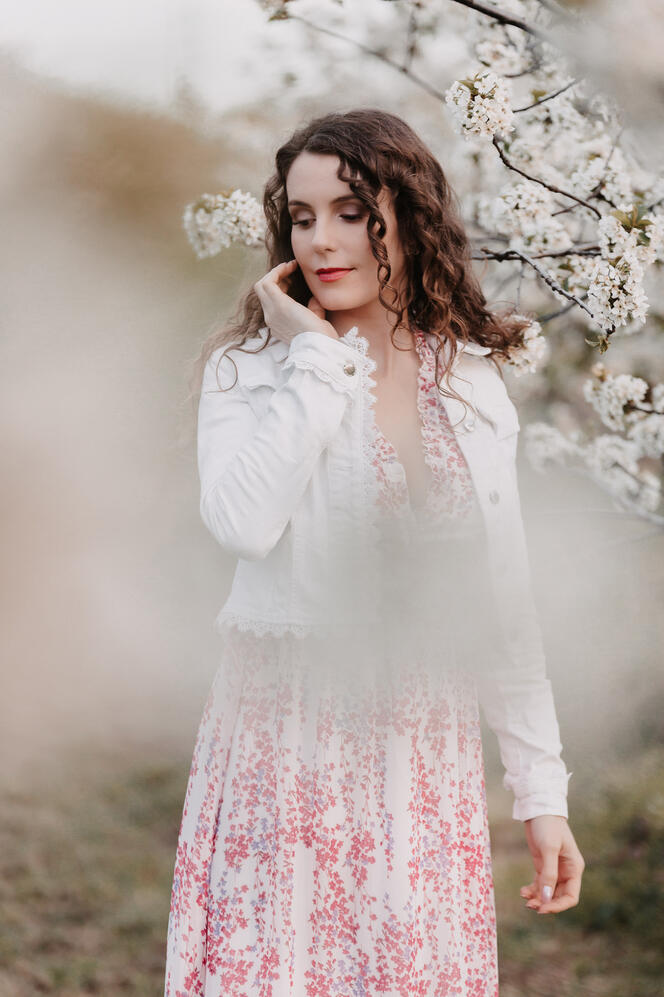 Lány fotózása a virágzó gyümölcsösben