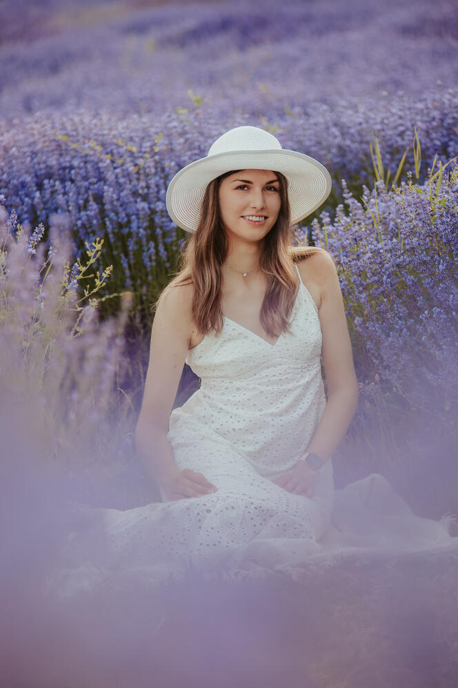 Egy kalapos lány fotózása a virágzó levendulásban