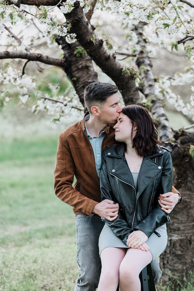 Szerelmes pár fotózása a virágzó gyümölcsösben